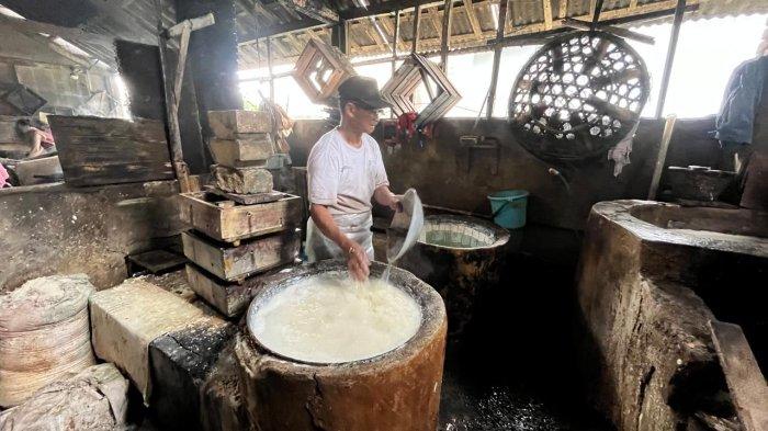 PERAJIN TAHU - Junaidi, perajin tahu di wilayah Kalibeber, Wonosobo sedang memasak tahu untuk dijual ke pelanggan, Kamis (17/4/2025). Ia bersiap naikan harga jual tahu atau kecilkan ukuran jika harga kedelai impor terus melambung tinggi.