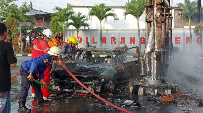 Petugas pemadam meyemprotkan air ke mobil yang hangus terbakar di SPBU Desa Dawung, Kecamatan Matesih, Kabupaten Karanganyar, Minggu (30/6/2024) sore.