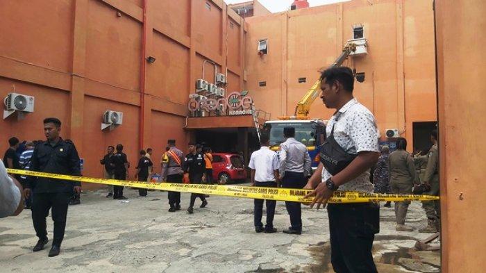 Pemasangan garis polisi di lokasi kebakaran Gedung Karaoke New Orange Tegal, Senin (15/1/2024).