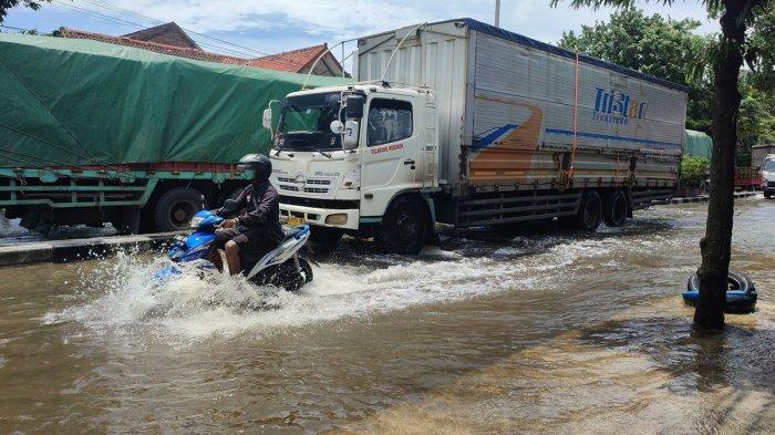 Pengendara motor nekat menerobos banjir yang masih merendam Jalan Woltermonginsidi termasuk di kelurahan Genuksari, Genuk, Kota Semarang, Sabtu (16/3/2024) siang. 