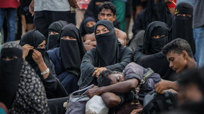 Pengungsi Rohingya yang baru tiba beristirahat di pantai setelah masyarakat setempat memutuskan untuk mengizinkan mereka sementara mendarat untuk mendapatkan air dan makanan di Ulee Madon, provinsi Aceh, Indonesia, pada 16 November 2023. Sekitar 250 pengungsi Rohingya mencapai Indonesia bagian barat dengan perahu kayu yang penuh sesak pada 16 November 2023, sehingga jumlah pengungsi yang dilaporkan oleh pejabat setempat tiba pada minggu ini menjadi hampir 600 orang. amanda jufrian / AFP