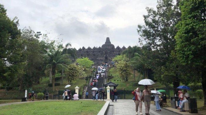 Pengunjung tampak menggunakan payung di Candi Borobudur Magelang saat sedang hujan.