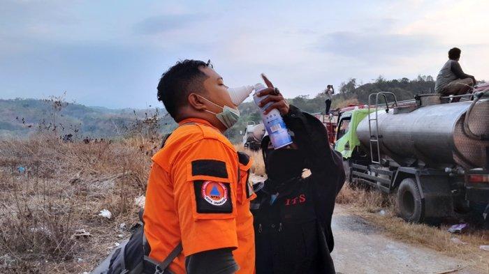Seorang petugas Damkar Kota Semarang mendapat pertolongan saat mengalami sesak napas dalam melakukan proses pemadaman di TPA Jatibarang Semarang, Senin (18/9/2023).