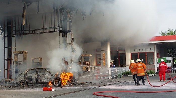 Petugas pemadam meyemprotkan air ke mobil yang hangus terbakar di SPBU wilayah Desa Dawung Kecamatan Matesih Kabupaten Karanganyar, Minggu (30/6/2024) sore.