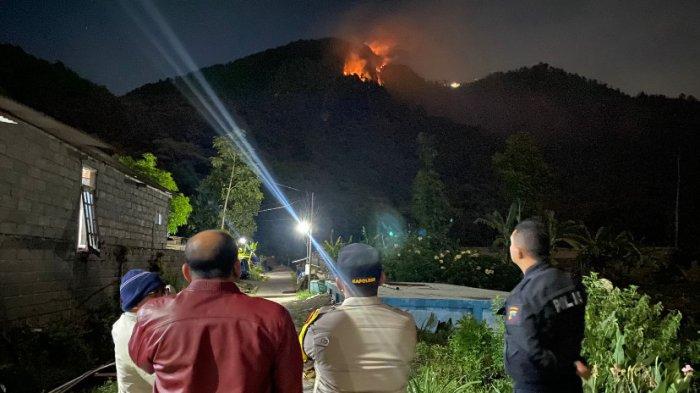 Polisi memantau kebakaran di lereng Gunung Telomoyo, Desa Tolokan, Kecamatan Getasan, Kabupaten Semarang, Rabu (18/9/2024) malam.