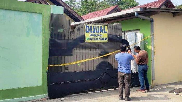 Polisi memasang garis polisi di lokasi penemuan 2 jasad membusuk di rumah Jl Sulawesi, Kota Blitar, Selasa (2/1/2024).