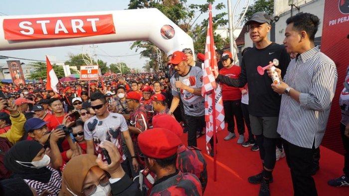Putra sulung Presiden Joko Widodo, Gibran Rakabuming Raka kembali mendampingi Ganjar Pranowo menyapa masyarakat. Usai ikut blusukan Ganjar ke Bogor kemarin, hari ini Minggu (23/7/2023) Wali Kota Solo itu mendampingi bacapres 2024 dari PDIP jalan sehat di Solo.
