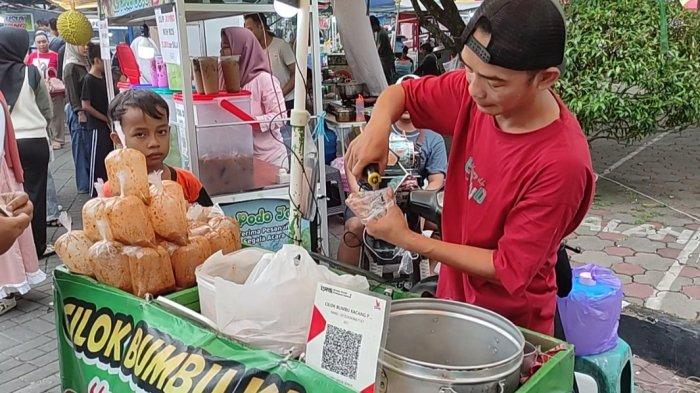 SCAN QRIS - Pedagang es teler Rp 5000 melayani pembeli yang sedang memindai kode QR untuk pembayaran digital lewat android, di Desa Dukuhwaluh, Kembaran, Banyumas, Kamis (27/3/2025).