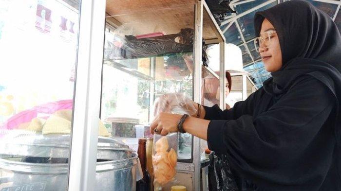 Saadah Fatimiyah (23), pedagang bubur di Alun-alun Tanjungsari, Sumedang, tengah melayani palanggannya, Rabu (8/11/2023) pagi.