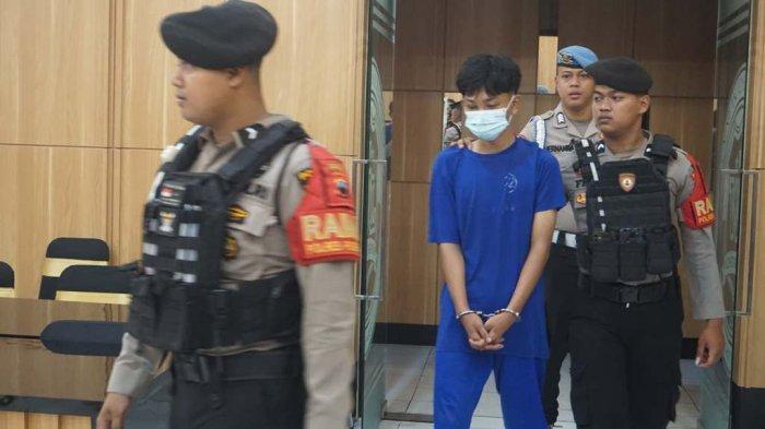 TERSANGKA TAWURAN: Salah satu tersangka tawuran saat sedang didampingi oleh polisi untuk mengikuti konferensi pers di Mapolres Purbalingga pada Sabtu (31/5/2025). Dalam kasus tersebut, polisi mengamankan beberapa bukti beberapa senjata tajam, handphone dan sepeda motor. (TRIBUN JATENG/Farah Anis Rahmawati)