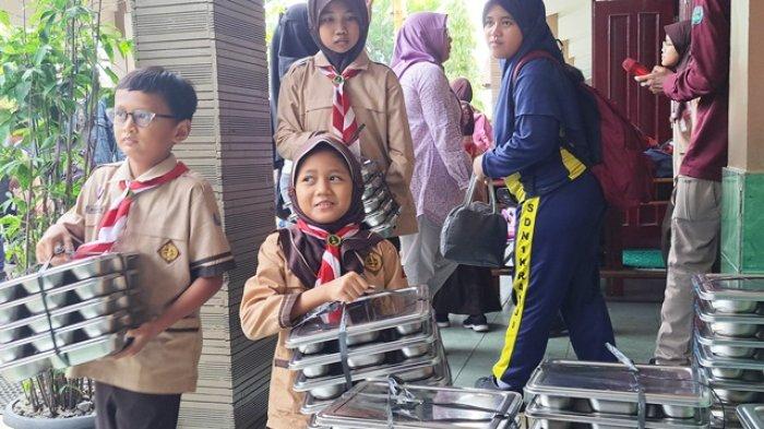 Sejumlah siswa di SDN 1 Kranji, Purwokerto saat ikut membereskan kotak makan bergizi gratis yang telah disantap, Jumat (10/1/2025).