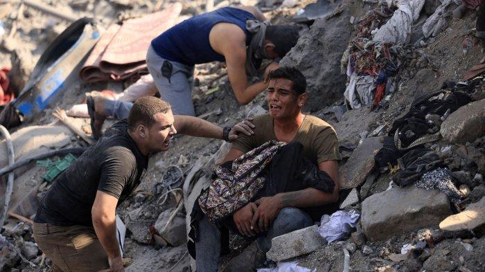 Ilustrasi - Seorang menggendong jenazah ibunya yang terbungkus selimut di tengah reruntuhan bangunan yang hancur dalam serangan Israel di kamp pengungsi Bureij di Jalur Gaza tengah pada 2 November 2023.