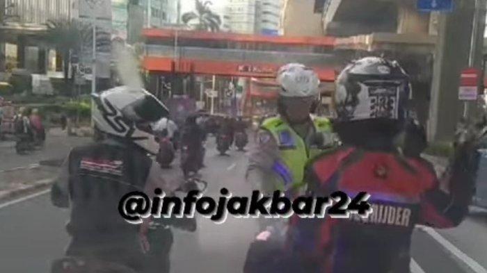 Seorang polisi memberhentikan motor relawan pengawal ambulans saat melakukan pengawalan di Jalan Rasuna Said, Kuningan, Jakarta Selatan, Senin (11/12/2023). 