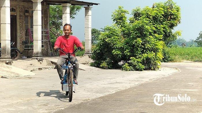 Andi Indriyawan Jajat Wibowo, warga Desa Karangpelem, Kecamatan Kedawung, Kabupaten Sragen menaiki sepeda bertenaga surya rakitannya, Sabtu (18/5/2024).