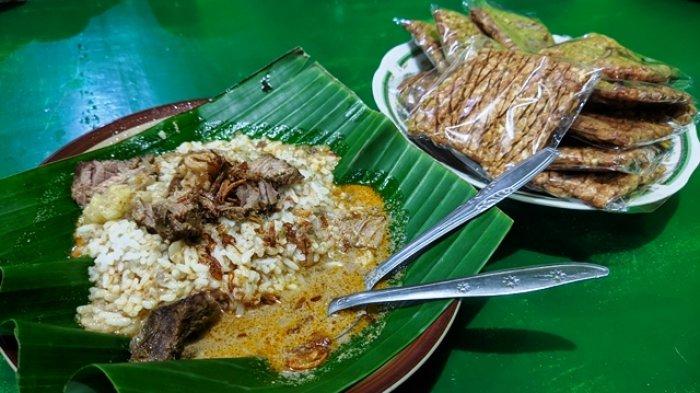Seporsi nasi gandul berlauk daging sapi dengan lauk pendamping berupa tempe yang digoreng kering.