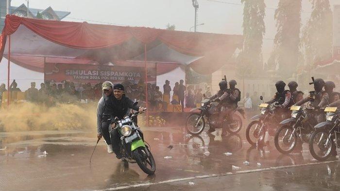 Massa aksi membawa senjata tajam di simulasi pengamanan Pilkada Kendal 2024 di depan Stadion Utama Kebondalem Kendal, Kamis (22/8/2024).