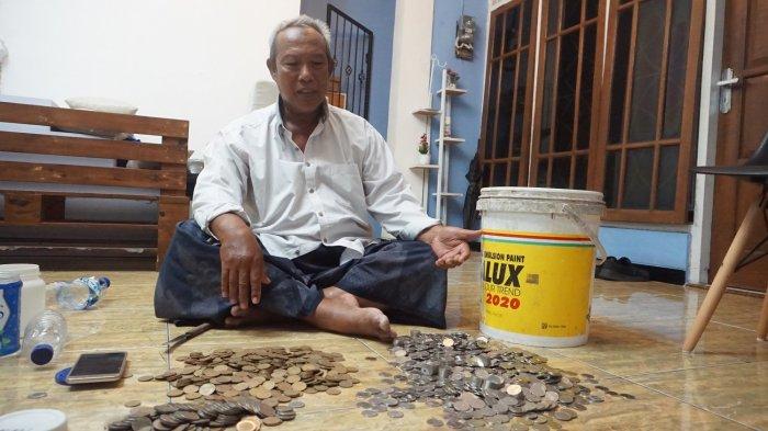 Sukamto (63) agen koran Tribun Jateng tunjukan sisa uang receh yang dikumpulkannya di dalam ember. Sebagian besar uang recehnya telah ditukarkan untuk berangkat Umrah.