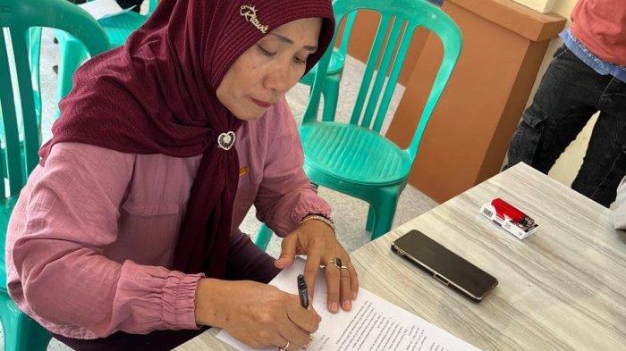 Sukati (54) menandatangani kesepakatan damai antara dirinya dengan panitia karnaval di Balai Desa Waturoyo, Kecamatan Margoyoso, Pati, Senin (12/8/2024).