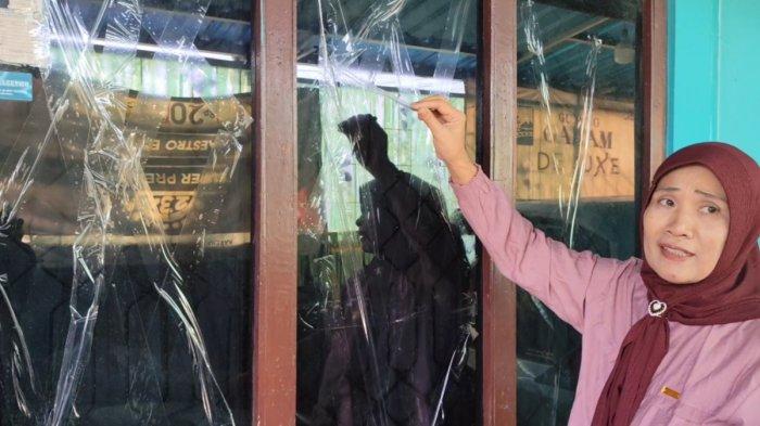 Sukati (54), warga Desa Waturoyo, Kecamatan Margoyoso, Pati, menunjukkan jendela rumah yang dia pasangi lakban demi menghindari kaca pecah akibat sound horeg, Senin (12/8/2024). 
 