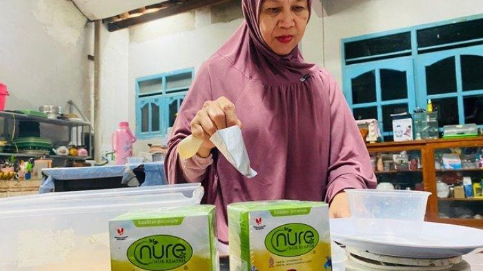TAKAR WEDANG JAHE: Ketua Kelompok Wanita Tani (KWT) Wijaya Kusuma Slawi Kulon yang juga pemilik merek Nur Food dan nure (Nur Rempah) Nur Hidayati, sedang menakar bahan wedang jahe plus rumput laut ngangeni ke dalam wadah untuk kemudian dikemas dan dipasarkan.