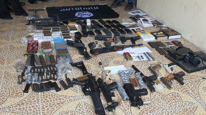 Tim Detasemen Khusus (Densus) 88 Antiteror Polri melakukan penggerebekan di rumah terduga teroris di Perumahan Pesona Anggrek Harapan, Bekasi Utara, Kota Bekasi, Senin (14/8/2023). Kediaman pemilik rumah sudah dibatasi garis polisi. Sejumlah anggota kepolisian berada di dalam rumah. Beberapa senjata api dan bendera yang terafiliasi ISIS dijejerkan di teras rumah terduga teroris berinisial DE tersebut.