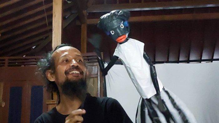 Pendiri Komunitas Wayang Sampah, Muhammad Suthoni yang akrab disapa Toni Konde memainkan salah satu tokoh wayang di sanggar seni wilayah Kecamatan Jaten Kabupaten Karanganyar pada Minggu (25/2/2024).
