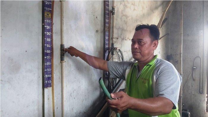 Penanggung jawab Rosikin memperlihatkan api dari biogas yang diolah dari limbah tahu di Dukuh Pesalakan, Desa Adiwerna, Kecamatan Adiwerna, Kabupaten Tegal, Selasa (13/8/2024). (TRIBUN JATENG/FAJAR BAHRUDDIN ACHMAD)