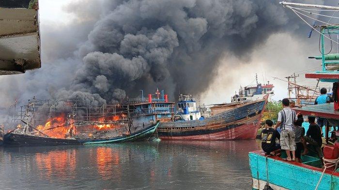 Warga dan nelayan tampak sedang melihat kapal nelayan yang terbakar di area Dok dan Galangan Kapal PT Pantai Mulia Semesta Tegal, Jumat (27/12/2024).