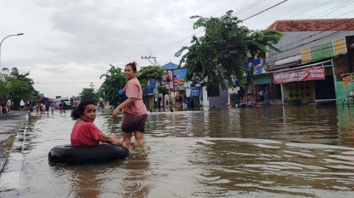 Warga Tegalsari, Kecamatan Gayamsari, Jumira (50), saat bermain renang di tengah banjir di Jalan Kaligawe Raya, Kota Semarang, Jumat (15/3/2024).