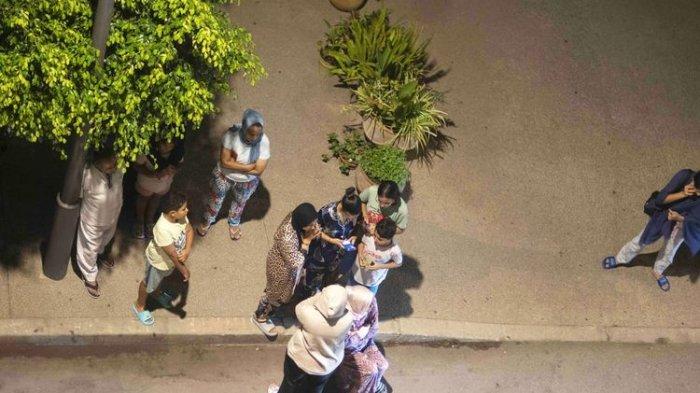 Orang-orang berlindung dan memeriksa berita di telepon genggam mereka setelah gempa bumi di Rabat, Maroko, pada hari Jumat (8/9/2023).(AP/Mosa'ab Elshamy)