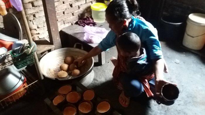 Irma, warga Desa Sampang, memasak nira aren dan mencetaknya dalam batok kelapa menjadi gula aren siap jual.