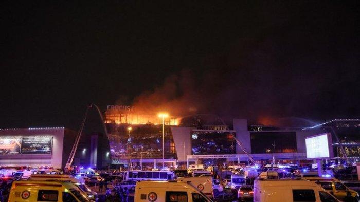 Kendaraan layanan darurat terlihat di luar gedung konser Balai Kota Crocus yang terbakar setelah insiden penembakan di Krasnogorsk, di pinggiran Moskwa, pada 22 Maret 2024. Orang-orang bersenjata melepaskan tembakan di gedung konser di pinggiran kota Moskwa pada 22 Maret 2024, menyebabkan tewas dan terluka sebelumnya kebakaran besar menyebar ke seluruh gedung, wali kota Moskwa dan kantor berita Rusia melaporkan. (STRINGER/AFP)