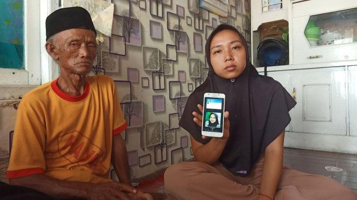 Kakak Rika Indriyeni (kanan) memperlihatkan foto almarhumah adiknya semasa hidup.