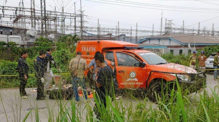 Sesosok mayat ditemukan dalam koper berwarna hitam yang tergelatak di pinggir Jalan Kalimalang, Desa Sukadanu, Kecamatan Cikarang Barat, Kabupaten Bekasi, Kamis (25/4/2024). Polisi langsung mendatangi tempat kejadian untuk mengidentifikasi korban.