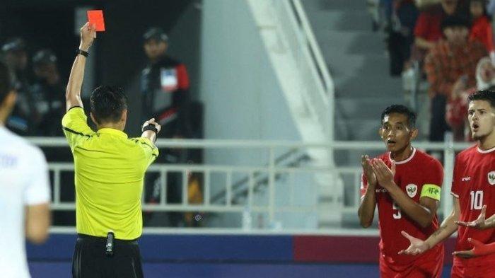 Wasit asal China Shen Yinhao memberikan kartu merah kepada bek Indonesia Rizky Ridho (#5) pada pertandingan semifinal Piala Asia U23 2024 antara Indonesia vs Uzbekistan di Stadion Abdullah Bin Khalifa di Doha pada 29 April 2024. (Foto oleh KARIM JAAFAR / AFP)(AFP/KARIM JAAFAR)