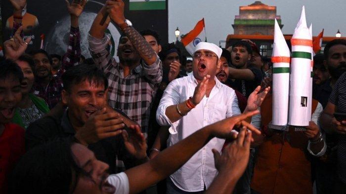 Orang-orang merayakan keberhasilan pendaratan pesawat ruang angkasa Chandrayaan-3 di bulan di kutub selatan Bulan, di New Delhi pada 23 Agustus 2023. India menjadi negara pertama yang berhasil mendaratkan pesawat ruang angkasa di kutub selatan Bulan pada 23 Agustus, tonggak sejarah terbaru dalam dorongan baru untuk eksplorasi bulan yang telah menarik kekuatan luar angkasa terkemuka dunia dan pemain baru. (Arun SANKAR / AFP)