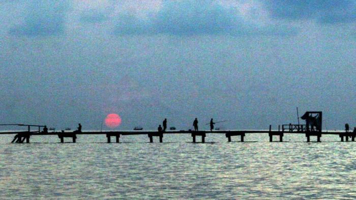 Pemancing pulang memancing di dermaga Pantai Widuri Pemalang, saat senja datang.