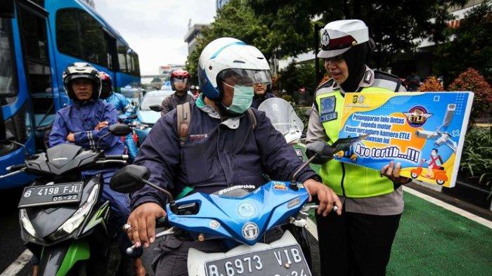 Petugas kepolisian dari direktorat lalu lintas (Ditlantas) Polda Metro Jaya menyosialisasikan penerapan sistem tilang elektronik atau electronic traffic law enforcement (ETLE) untuk kendaraan roda dua atau motor di Simpang Sarinah, Thamrin, Jakarta Pusat, Senin (3/2/2020). Untuk saat ini sistem ETLE untuk pengendara sepeda motor fokus pada penindakan tiga pelanggaran, yakni penggunaan helm, menerobos traffic light, dan melanggar marka jalan. Penerapan aturan tersebut telah resmi diberlakukan mulai Sabtu (1/2/2020).