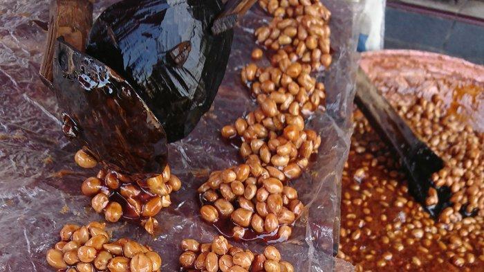 GULA KACANG - Listiana membuat gula kacang atau ampyang di Pasar Raya Salatiga, Jumat (12/1/2024). Pembeli bisa menikmati ampyang hangat di tempat ini. (Christiana Adinugraheni, Mahasiwa UKSW Magang di Tribun Jateng)