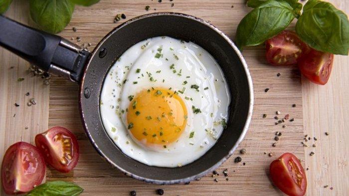 Ilustrasi telur ceplok atau telur mata sapi di wajan teflon.