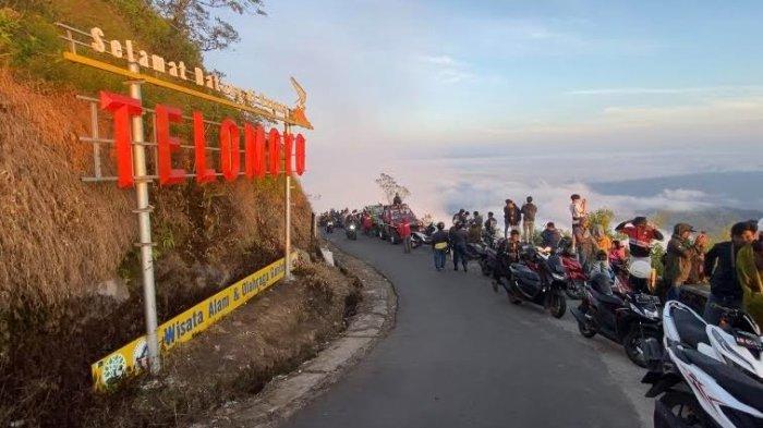 SERASA DI ATAS AWAN - Wisatawan berjejer di tepi jalan menikmati pemandangan alam seperti pegunungan, matahari terbit dan awan dari puncak Gunung Telomoyo, Desa Sepakung, Kecamatan Banyubiru, Kabupaten Semarang, Minggu (2/7/2023) pagi. Puncak gunung tersebut bisa diakses menggunakan kendaraan bermotor.
