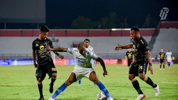 Striker Persib Bandung, David da Silva mencoba mempertahankan bola dari rebutan pemain Persebaya.