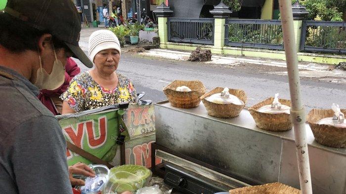 TIWUL HANGAT - Penyajian cemilan tiwul hangat dengan cita rasa alami disukai pembeli. Parno berjualan tiwul hangat di Pasar Pasekan Boyolali. (Tribun Jateng)