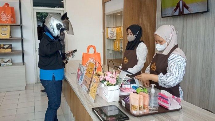 Pengunjung (memakai helm) tengah melakukan transaksi pembayaran usai berbelanja di outlet ketiga Lapis Kukus Lawang Sewu di Jalan Setia Budi No. 91 Semarang pada Senin (7/11/2022).