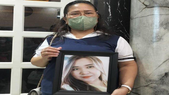 Ana Mariana, membawa foto anaknya, Angeline Nathanie. Putrinya yang merupakan mahasiswi Ubaya dibunuh guru les musik.