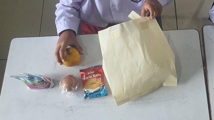 ANGGARAN MBG DIPANGKAS - Siswa SDN 1 Wonosari, Gunungkidul, membuka Paket makan bergizi gratis (MBG), Kamis (6/3/2025). KPK mencurigai adanya pemangkasan tak bertanggung jawab hingga akhirnya makanan di program MBG berkurang mencapai hanya Rp 8 ribu satu porsi.