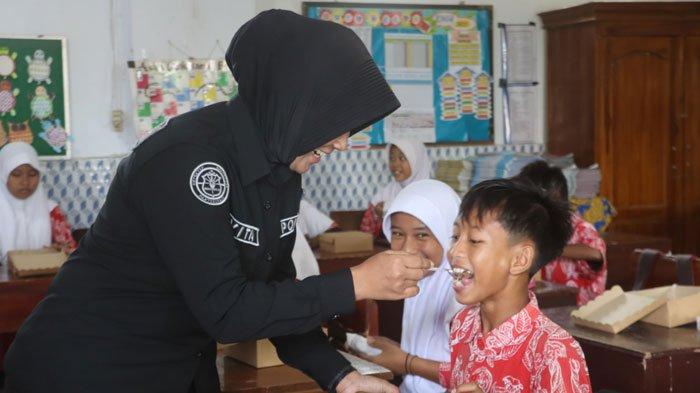 Anggota Polres Probolinggo saat menjalankan program Makan Bergizi Gratis atau MBG.