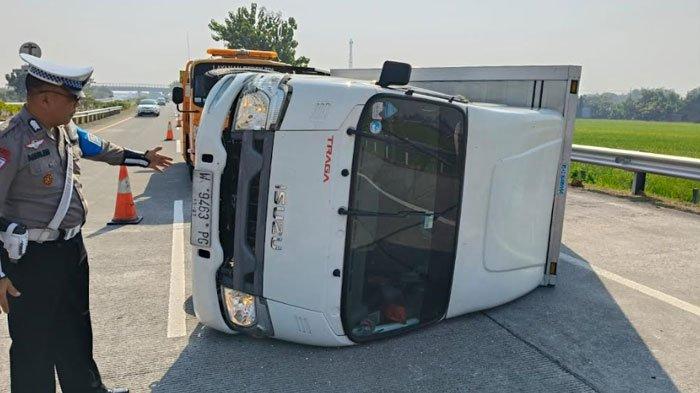 Anggota Satuan PJR Ditlantas Polda Jatim melakukan olah TKP truk boks bermuatan kain yang terguling di Tol Jombang-Mojokerto, KM 701.800 Jalur B, pada Senin (2/8/2024).