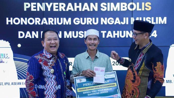 Bupati Jember Hendy Siswanto (kiri) serahkan pencairan honor guru ngaji secara simbolis