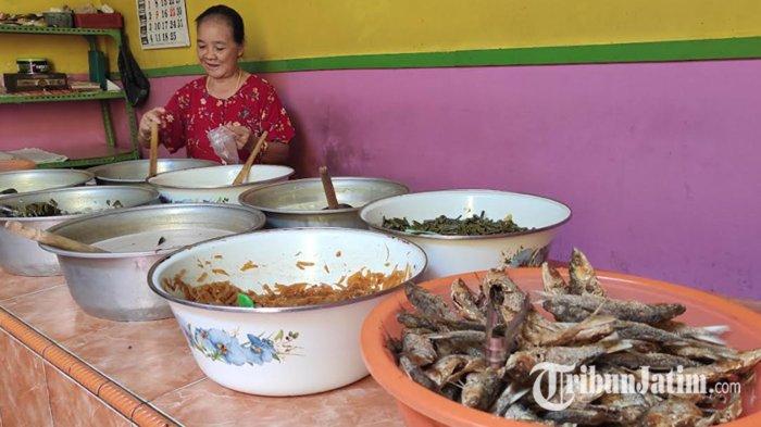 Mak Ti sedang memasukkan sayur lodeh ke plastik untuk pembeli yang dibawa pulang di warungnya, Desa Jatinom, Kecamatan Kanigoro, Kabupaten Blitar, Selasa (21/5/2024).
